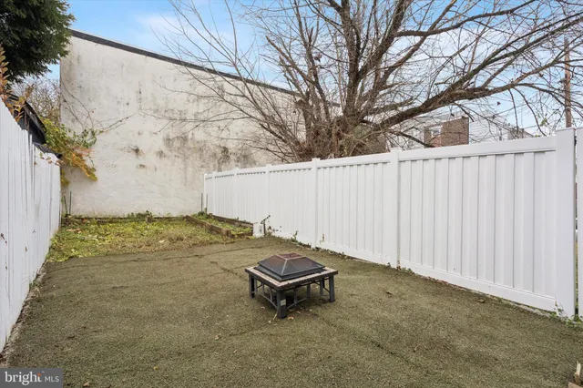a view of a backyard with white fence