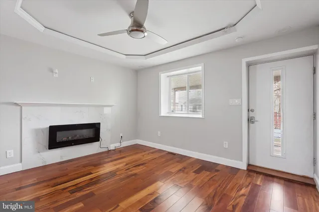 a view of empty room with wooden floor and fireplace