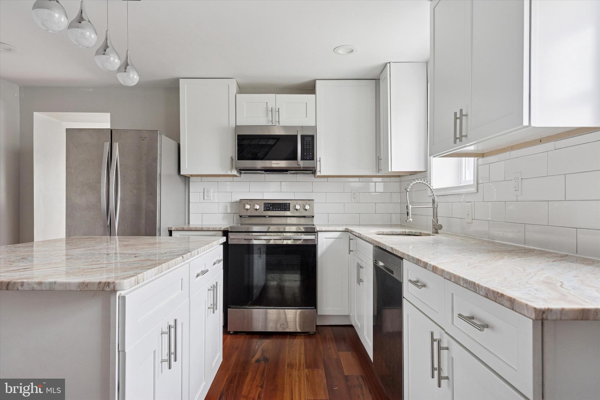 213 East Phil Ellena Street Philadelphia, PA 19119 - Photo 7 of 28 a kitchen with stainless steel appliances granite countertop a sink stove microwave and refrigerator