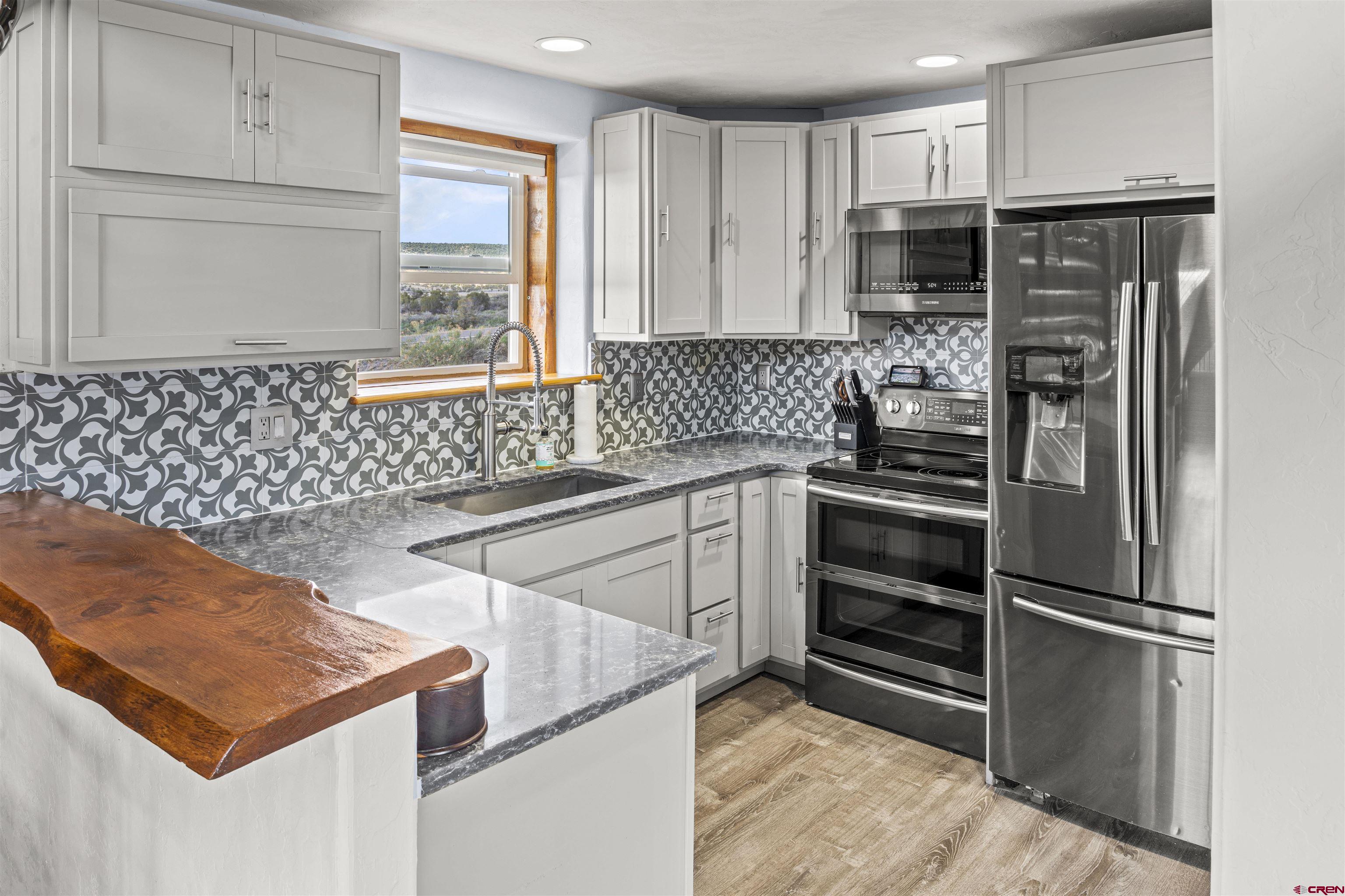70848 Buckhorn Road Montrose, CO 81403 - Photo 15 of 43 a kitchen with a refrigerator and a stove top oven