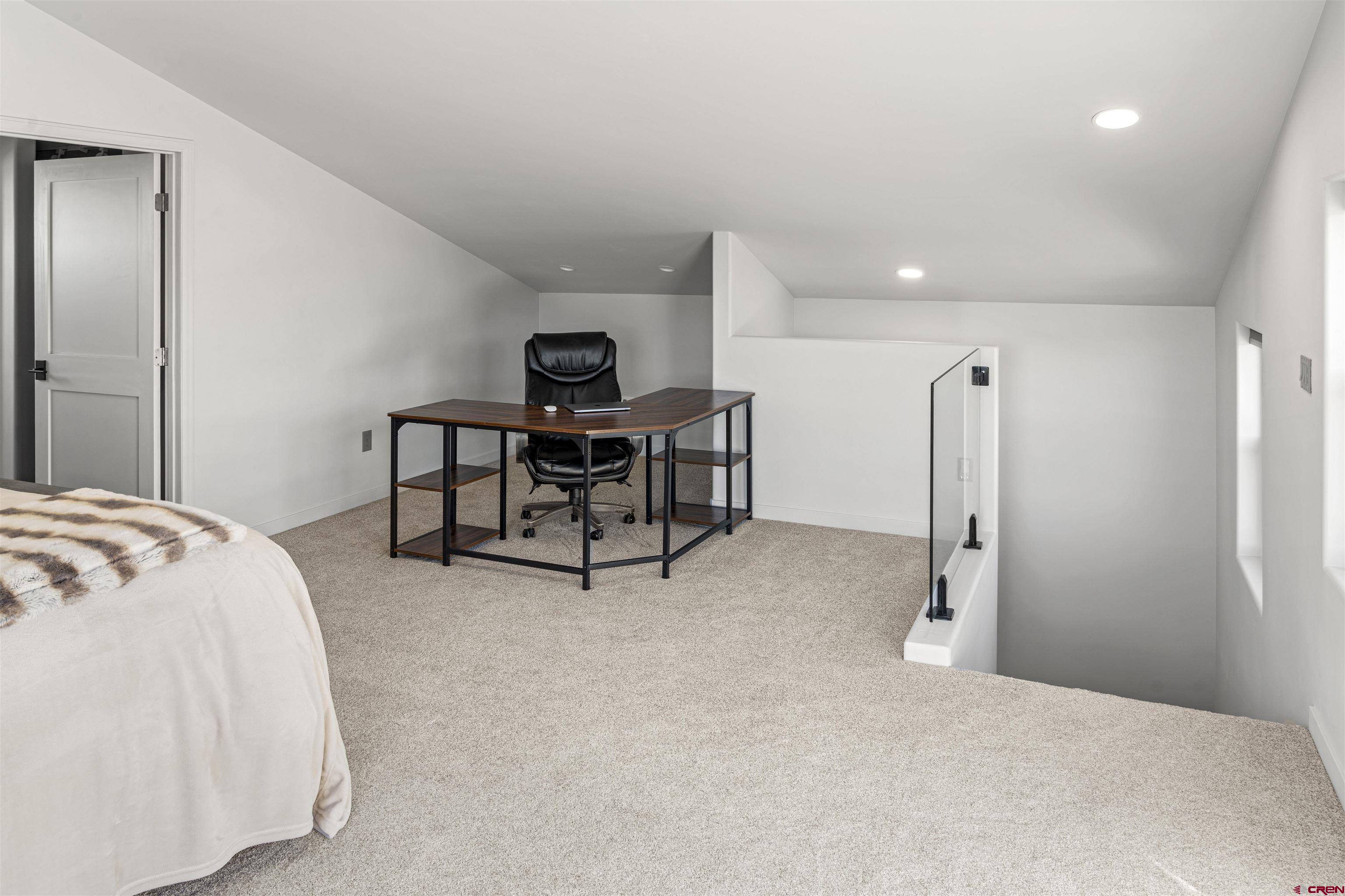 70848 Buckhorn Road Montrose, CO 81403 - Photo 32 of 43 a spacious bedroom with a bed and a table in it