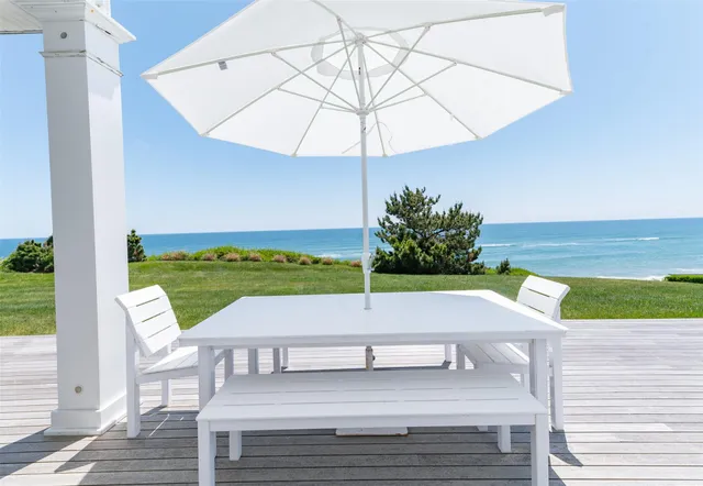 a view of a patio with a table and chairs under an umbrella