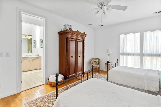 a bedroom with two beds and large windows