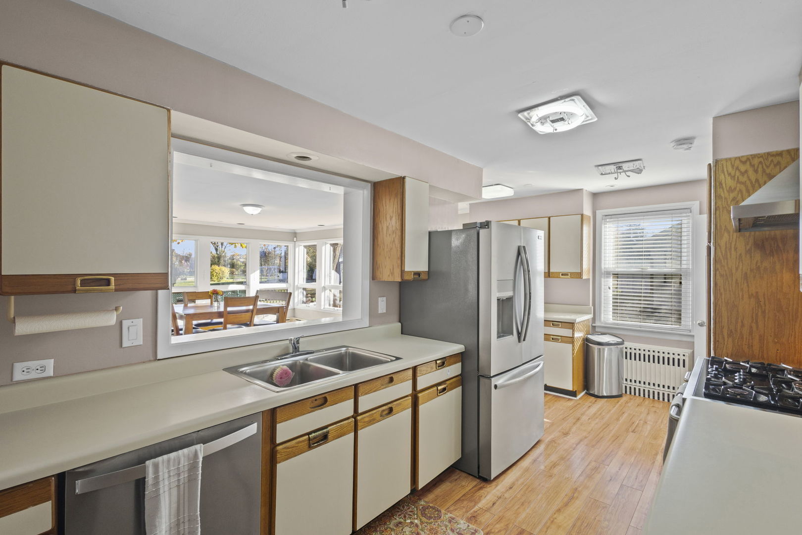 1615 Greenwood Road Glenview, IL 60026 - Photo 14 of 41 a kitchen with stainless steel appliances a refrigerator a sink a stove and white cabinets with wooden floor