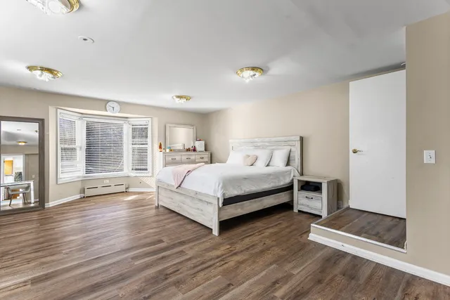 a bedroom with a bed and wooden floor