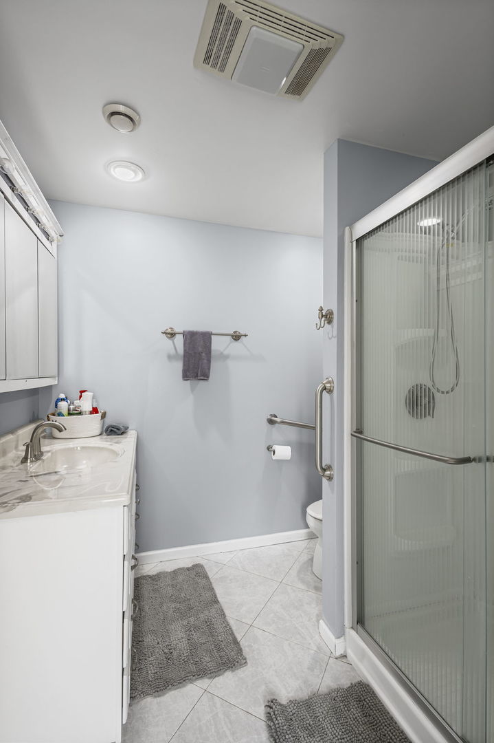 1615 Greenwood Road Glenview, IL 60026 - Photo 25 of 41 a bathroom with a granite countertop sink a toilet and shower