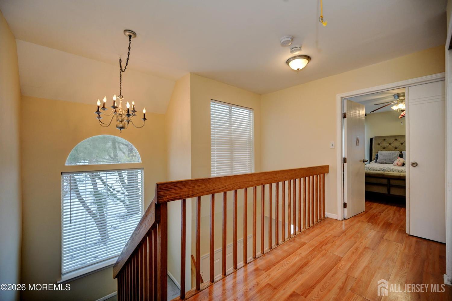 22 Borell Square Parlin, NJ 08859 - Photo 22 of 32 a view of a hallway with wooden floor and a chandelier