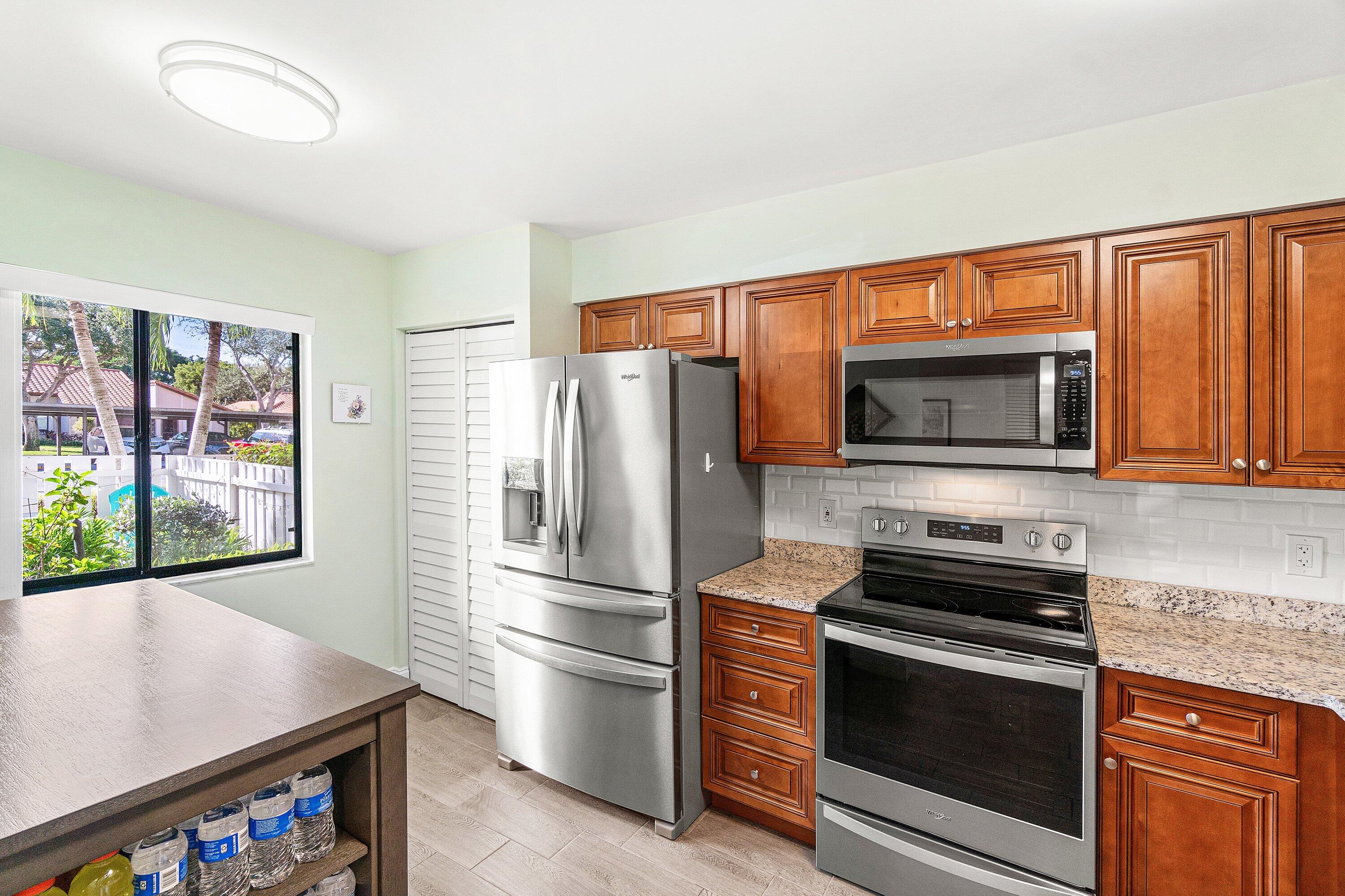 6149 Pointe Regal Circle, Unit 108 Delray Beach, FL 33484 - Photo 13 of 56 a kitchen with stainless steel appliances a refrigerator stove and microwave