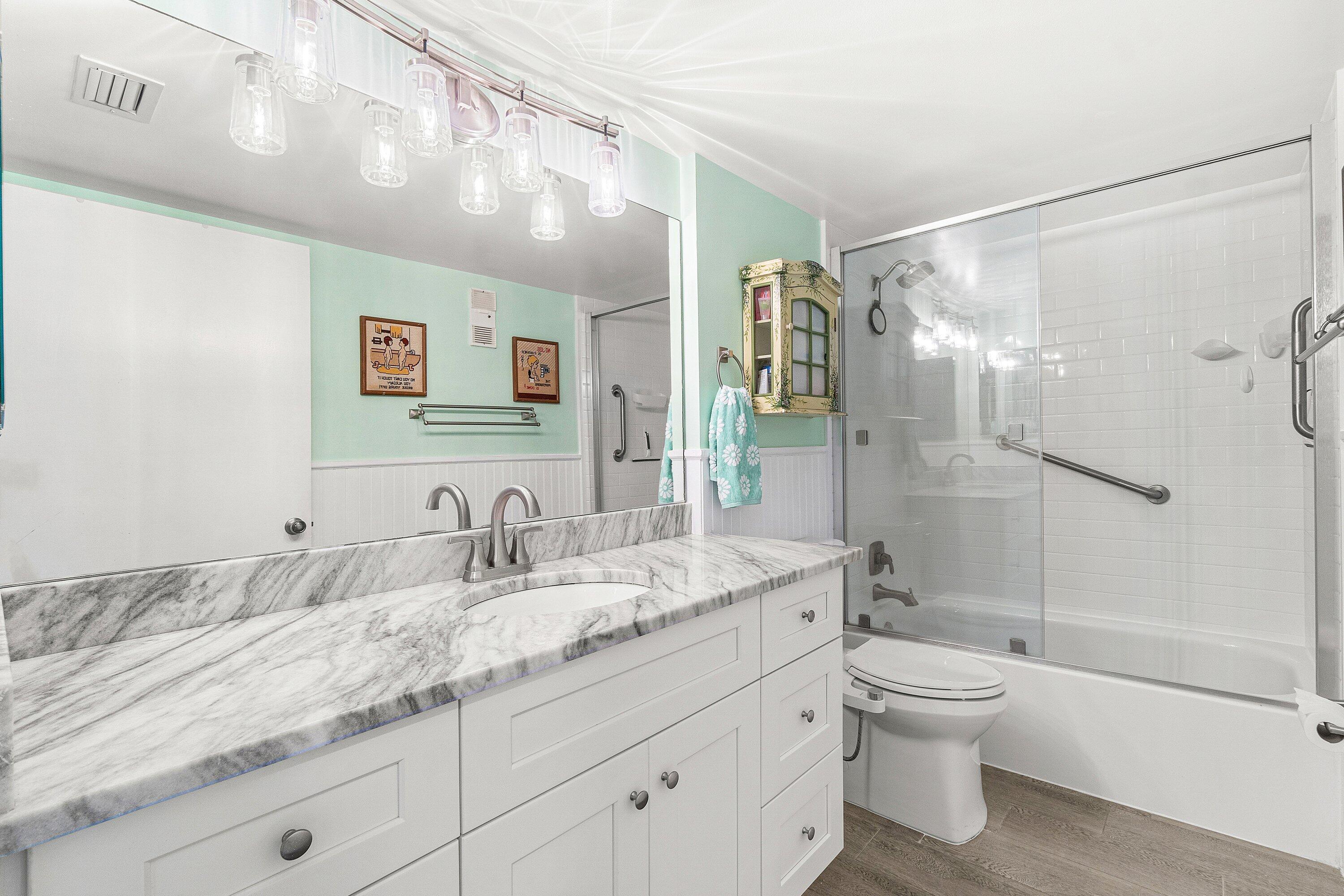 6149 Pointe Regal Circle, Unit 108 Delray Beach, FL 33484 - Photo 17 of 56 a bathroom with a granite countertop sink a toilet and shower