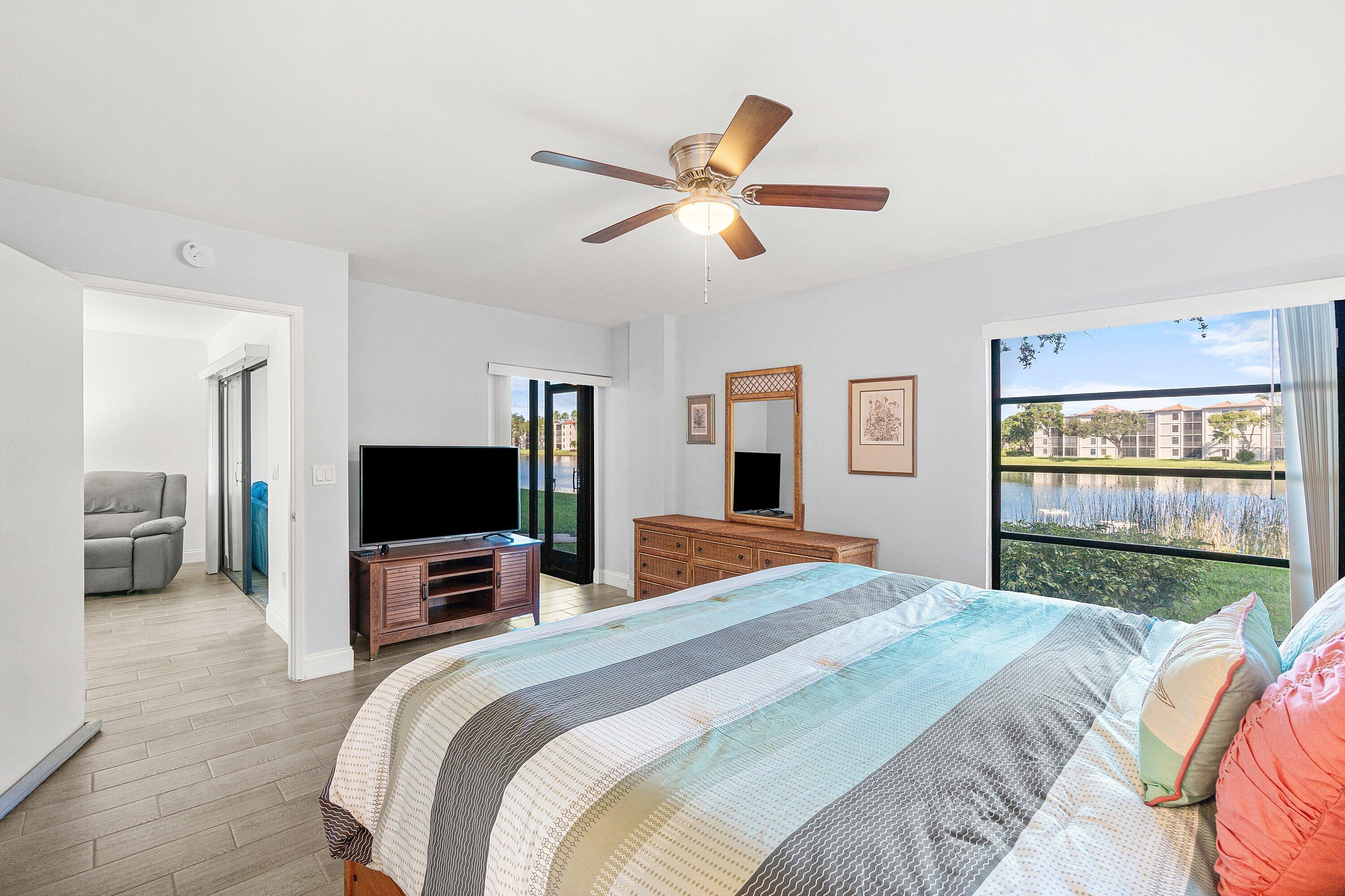 6149 Pointe Regal Circle, Unit 108 Delray Beach, FL 33484 - Photo 19 of 56 a bedroom with a bed and a flat screen tv