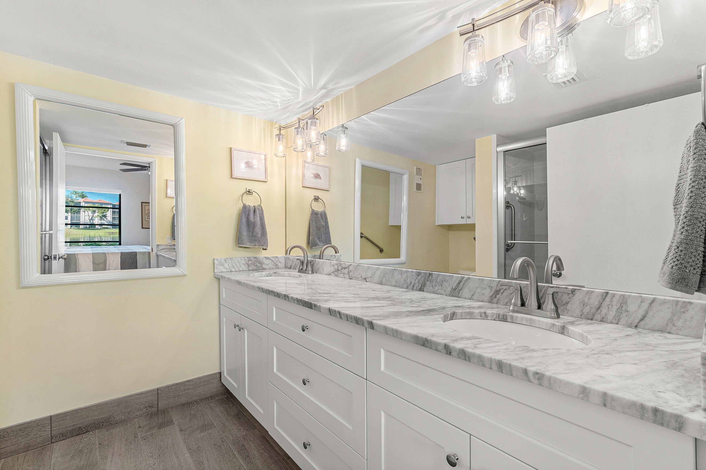 6149 Pointe Regal Circle, Unit 108 Delray Beach, FL 33484 - Photo 21 of 56 a bathroom with a granite countertop double vanity sink and mirror