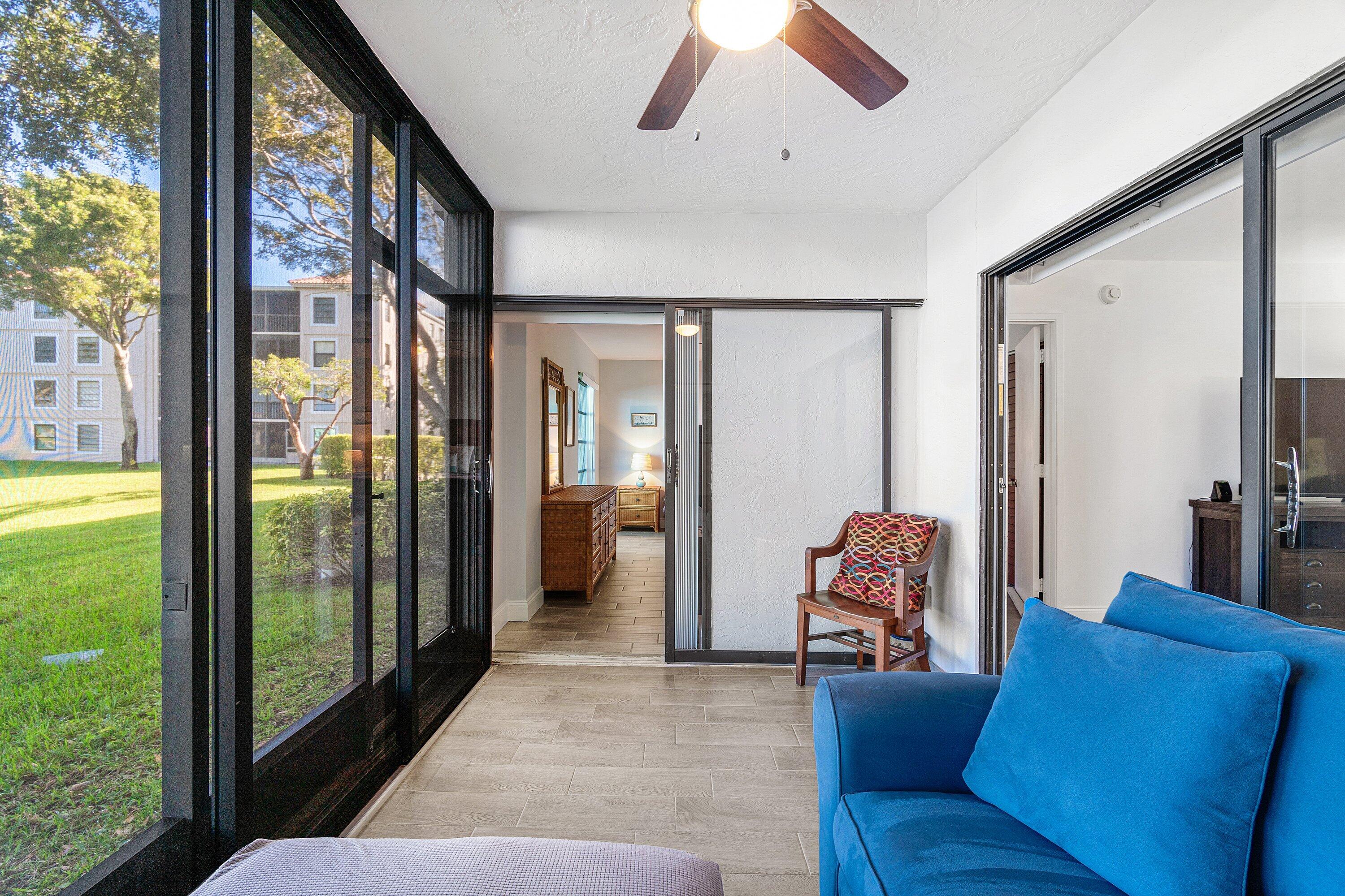 6149 Pointe Regal Circle, Unit 108 Delray Beach, FL 33484 - Photo 27 of 56 a living room with furniture and a floor to ceiling window