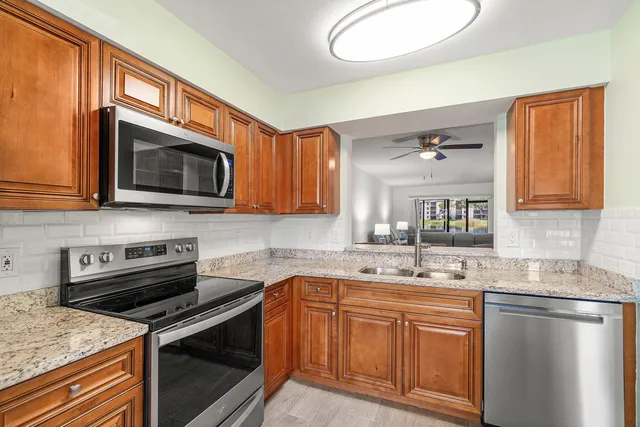 a kitchen with stainless steel appliances granite countertop a refrigerator and a sink