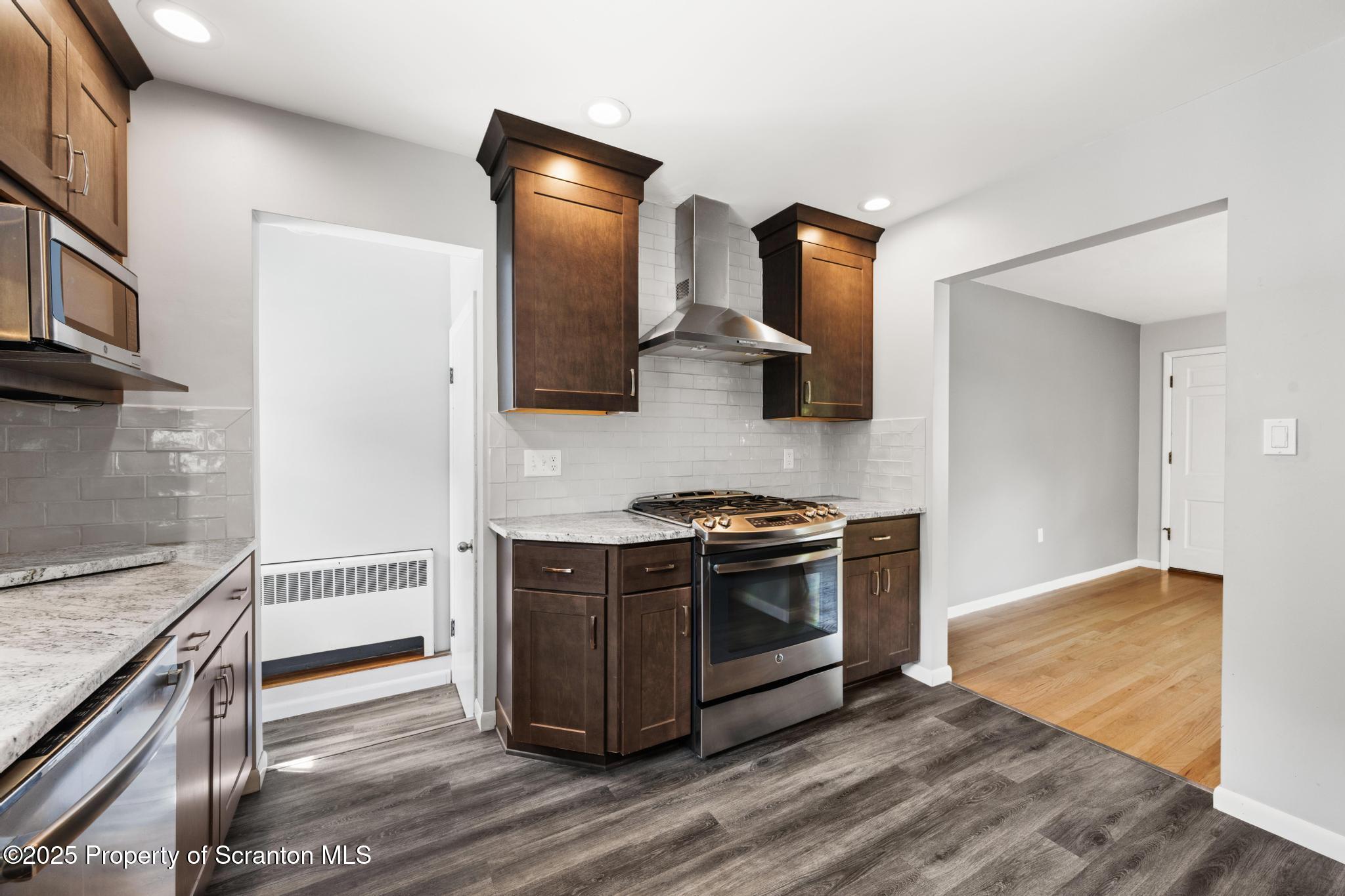 525 Knapp Road Clarks Summit, PA 18411 - Photo 11 of 45 a kitchen with stainless steel appliances wooden floor and a stove top oven