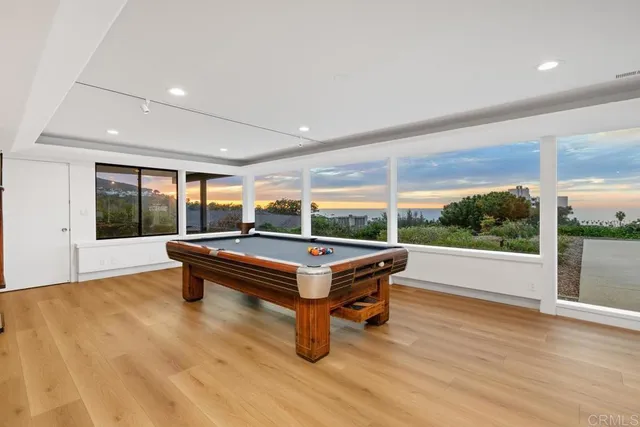 a room with pool table and wooden floor