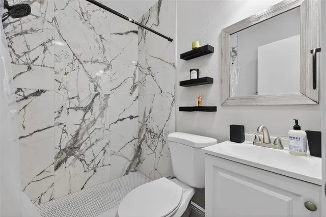 a bathroom with a toilet sink and cabinets