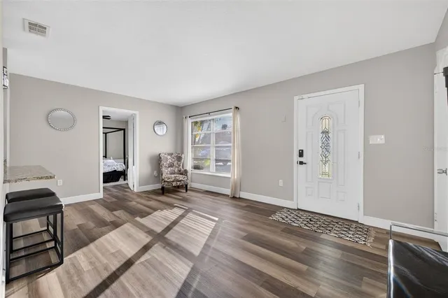 a living room with furniture a dining table and wooden floor