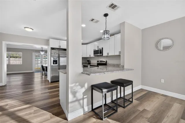 a kitchen with granite countertop white cabinets and stainless steel appliances