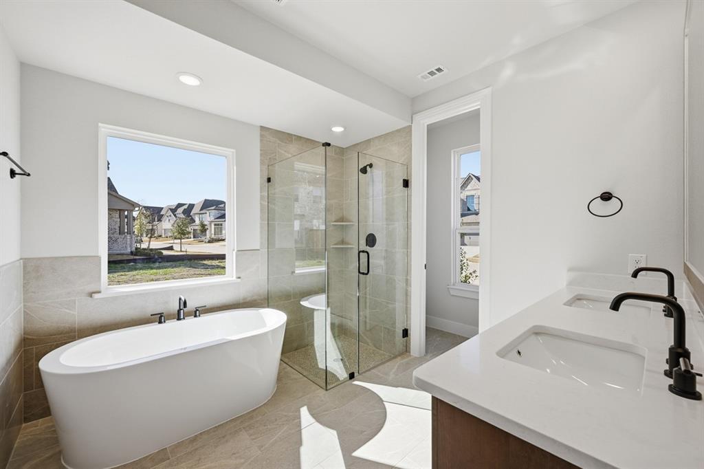 4408 Daisy Lane Prosper, TX 75078 - Photo 14 of 25 a bathroom with a white tub a sink and glass door