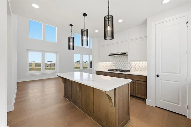 a kitchen that has a kitchen island wooden floor and stainless steel appliances