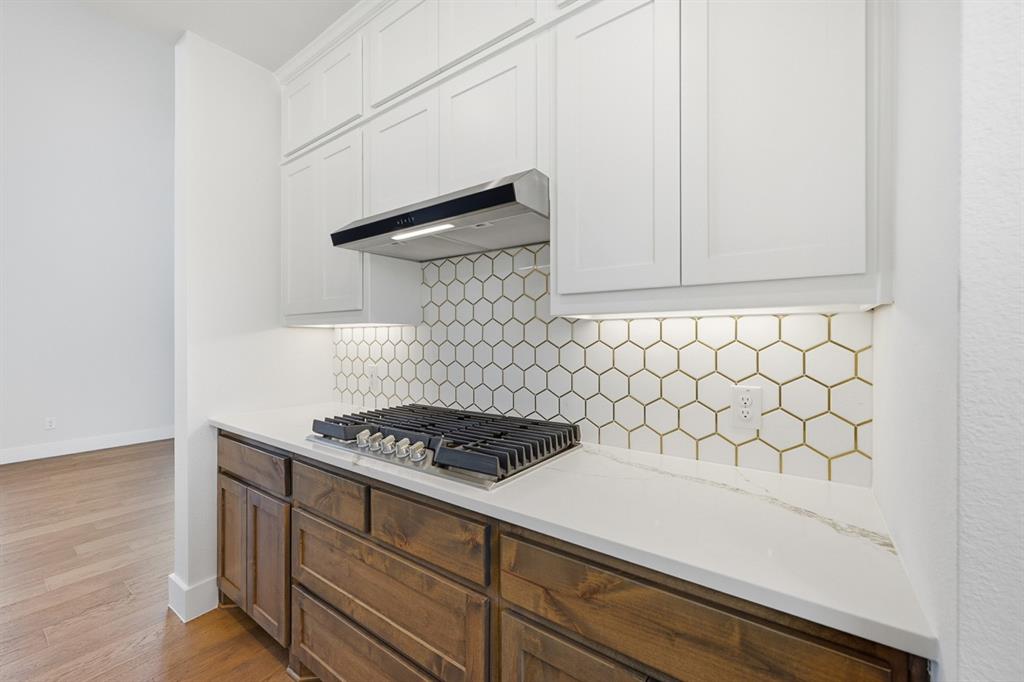 4408 Daisy Lane Prosper, TX 75078 - Photo 6 of 25 a kitchen with white cabinets and a stove