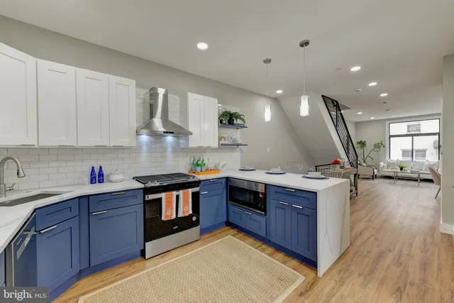 a kitchen with stainless steel appliances granite countertop a sink a stove and a wooden floors