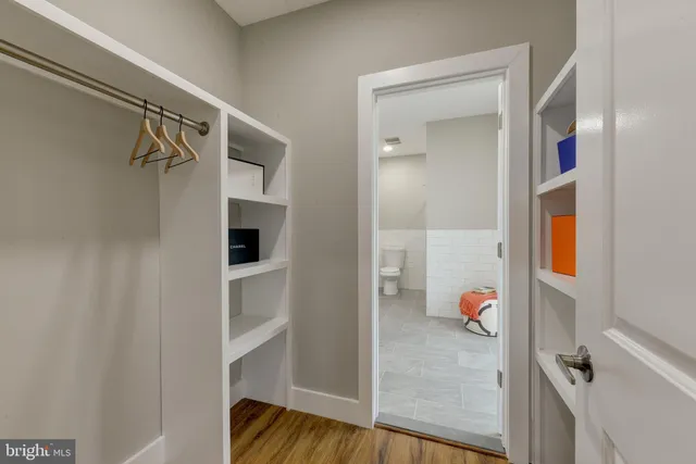a view of walk in closet with clothes and shoes