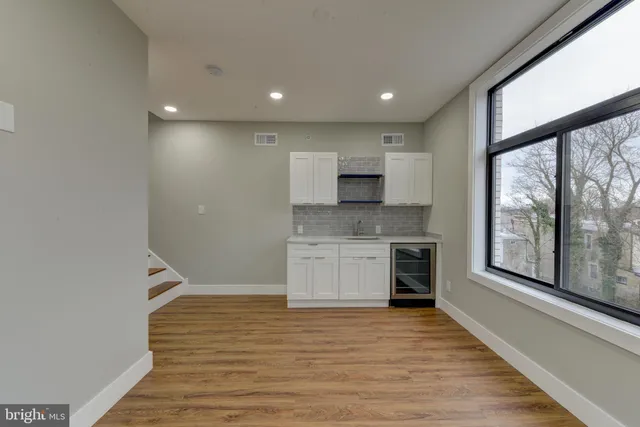 a view of a kitchen with a sink and dishwasher wooden floor