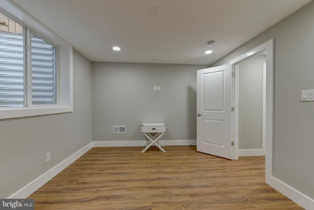 a view of empty room with wooden floor
