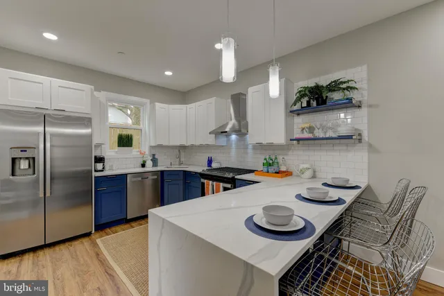 a kitchen with stainless steel appliances granite countertop a sink a refrigerator and a stove