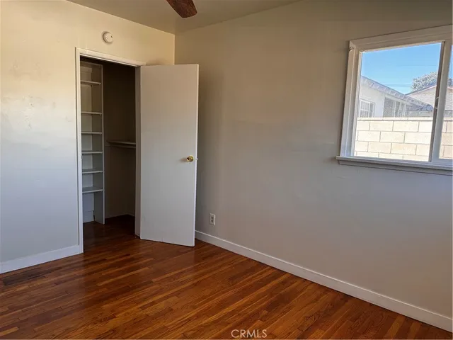 an empty room with wooden floor and a window