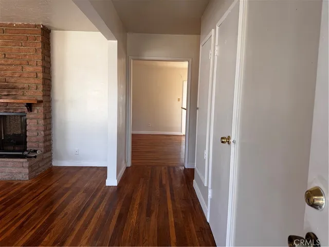a view of a hallway with wooden floor and a fireplace