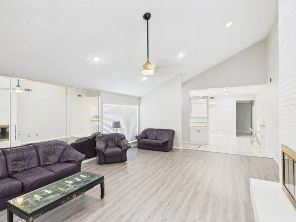 a living room with furniture and a wooden floor
