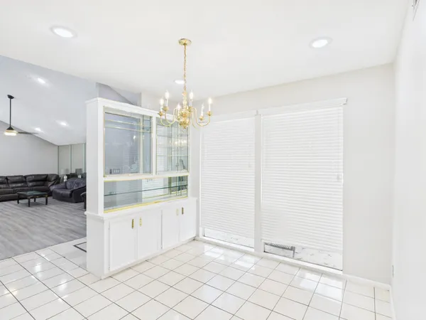 a room with lots of white furniture and wooden floor