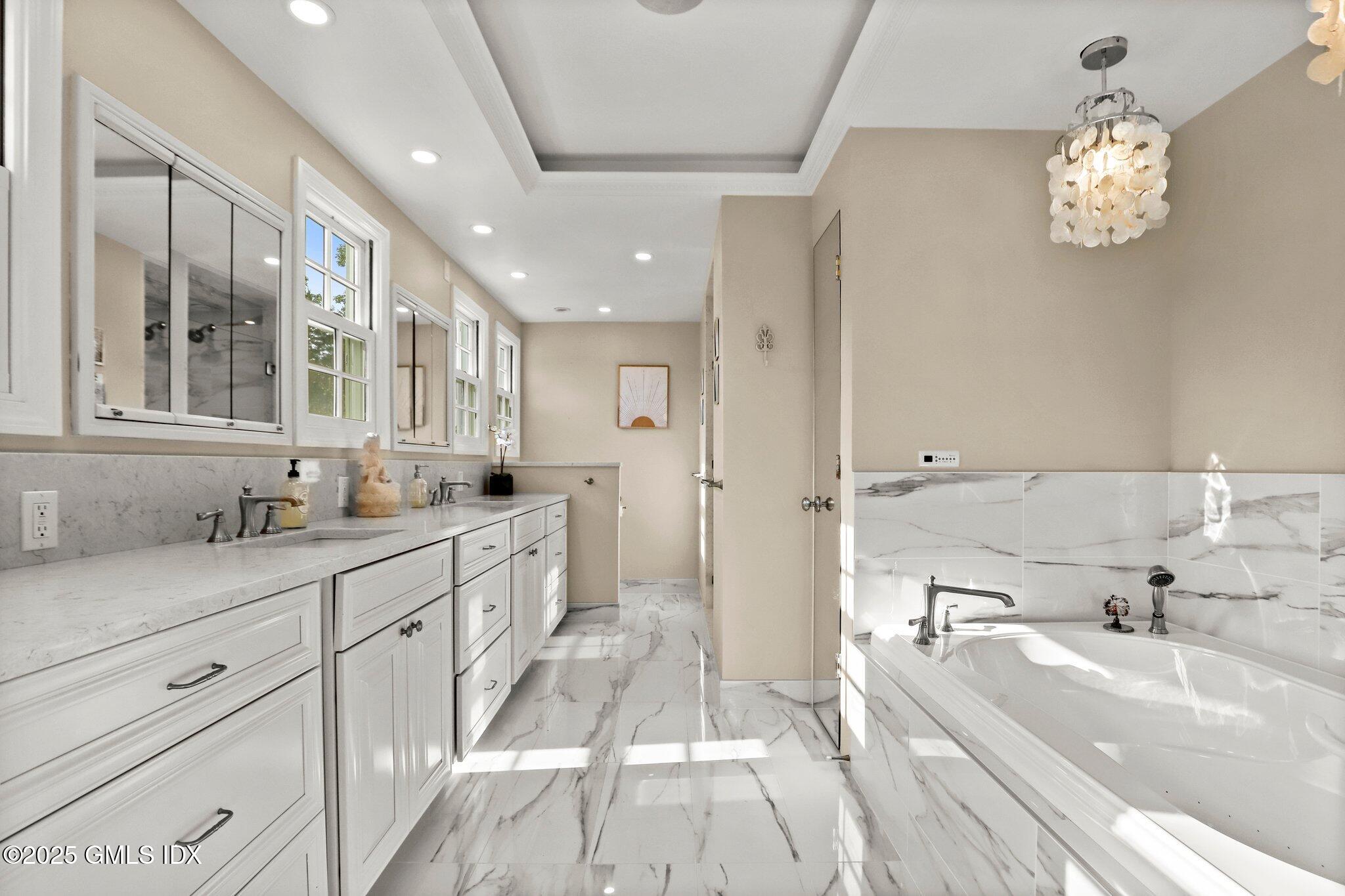12 Old Forge Road Greenwich, CT 06830 - Photo 15 of 34 a spacious bathroom with a tub sink and mirror