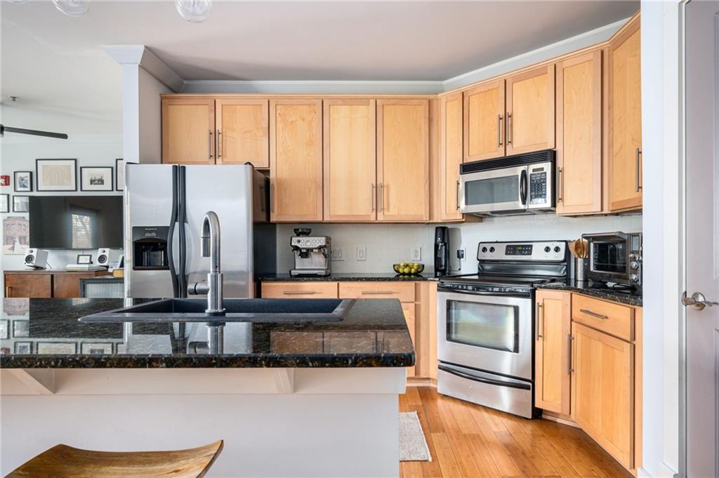 1628 Briarcliff Road Northeast, Unit 9 Atlanta, GA 30306 - Photo 5 of 25 a kitchen with stainless steel appliances granite countertop a stove top oven a sink and a microwave
