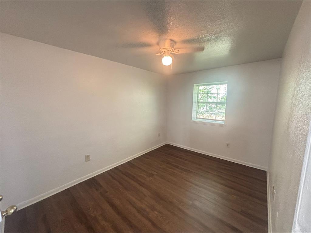 612 Luxton Street, Unit 202 Fort Worth, TX 76104 - Photo 5 of 5 an empty room with wooden floor and windows