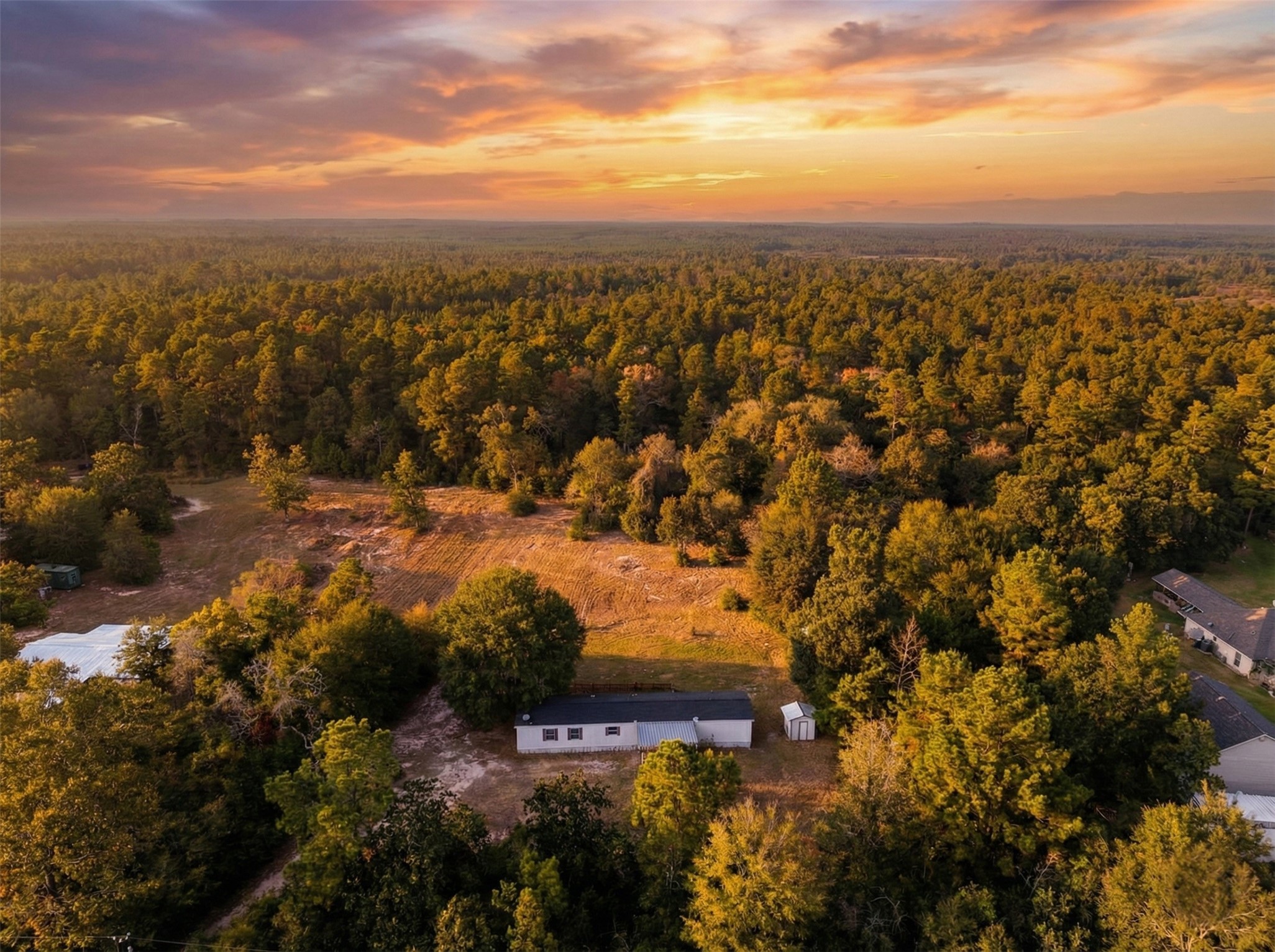 6493 Pappas Road Waller, TX 77484 - Photo 2 of 28 Sunset Aerial view of this 2.32-acre private retreat in West Magnolia Forest, Waller TX, featuring mature trees and expansive open space.