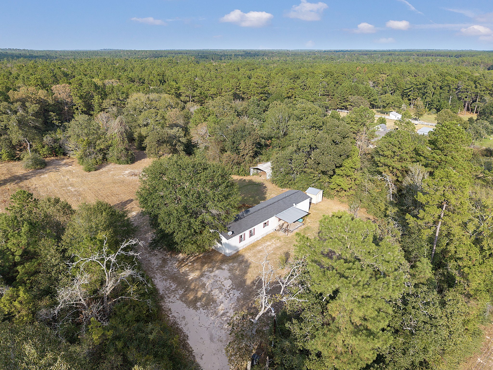 6493 Pappas Road Waller, TX 77484 - Photo 25 of 28 Aerial view showcasing 2.32 acres of privacy, mature tree coverage, and open usable land in West Magnolia Forest.
The home is set back from the road, surrounded by natural canopy with no rear neighbors and uninterrupted green space beyond—capturing the scale, separation, and acreage lifestyle that define this Grimes County location near the US-290 corridor.