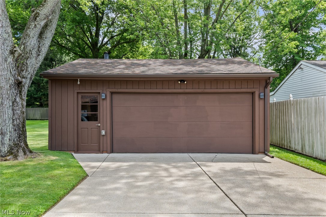 17583 Shurmer Road Strongsville, OH 44136 - Photo 41 of 50 Detached garage featuring a single overhead door and a separate entry door with an upper glass panel
