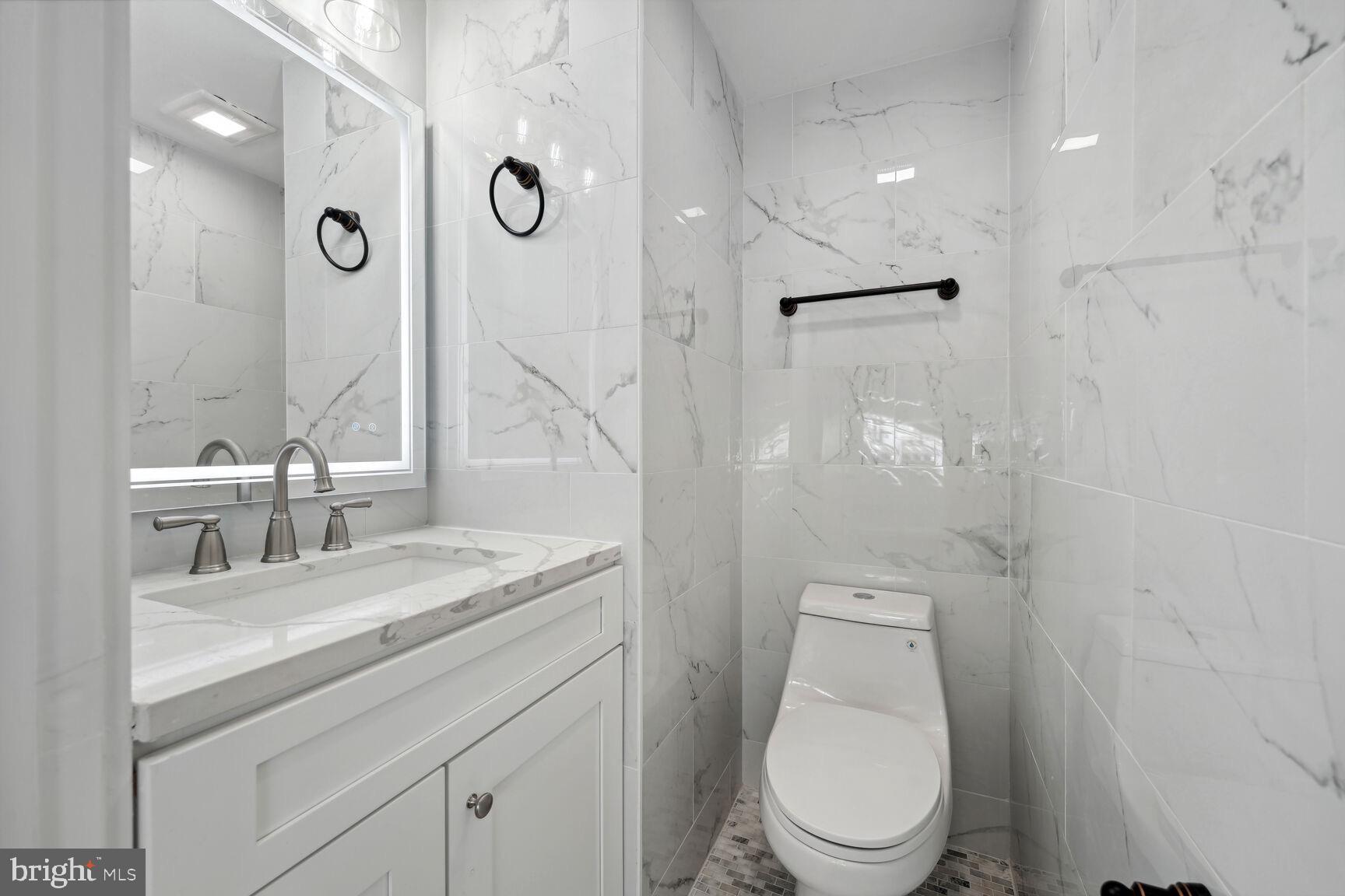 704 Rittenhouse Street Northwest Washington, DC 20011 - Photo 12 of 29 a bathroom with a granite countertop toilet sink and mirror