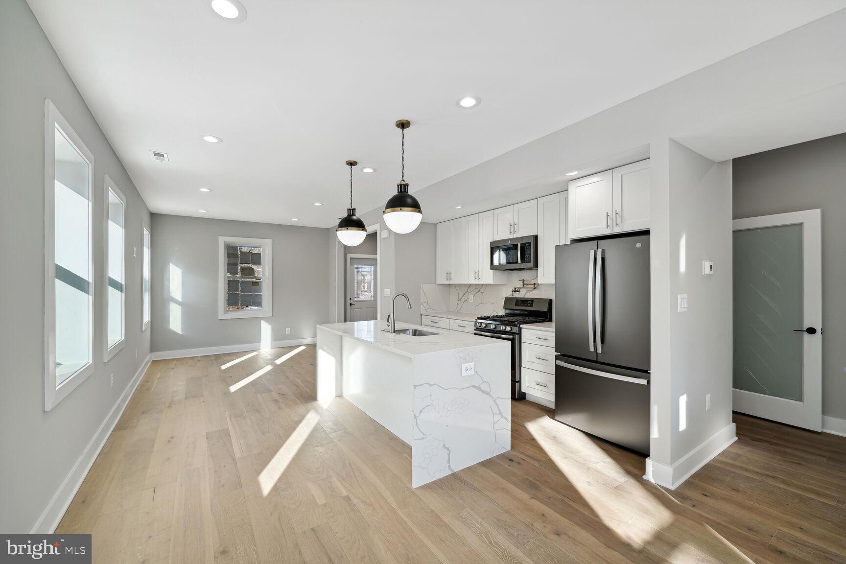 704 Rittenhouse Street Northwest Washington, DC 20011 - Photo 8 of 29 a large kitchen with stainless steel appliances a large counter top a sink a refrigerator and a window