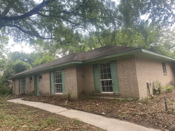 a front view of a house with a yard and trees
