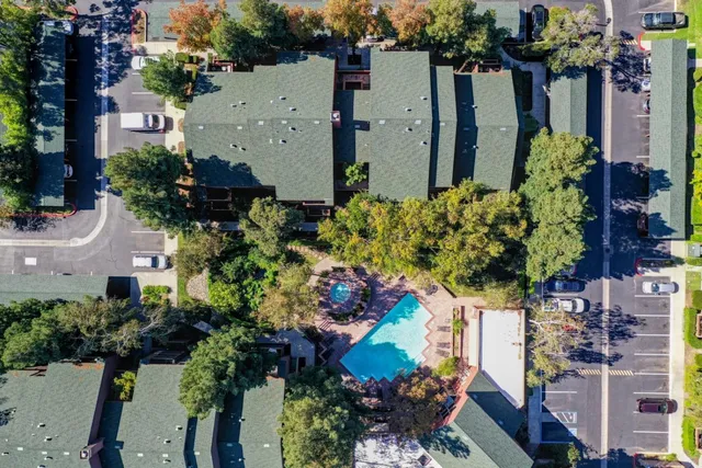 front view of a house with a yard and a lot of flower plants