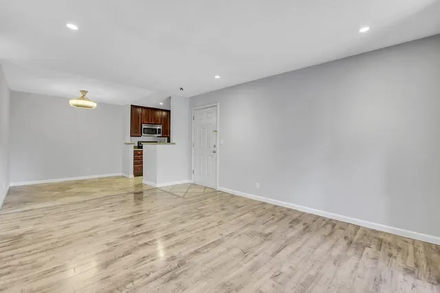 a view of empty room with wooden floor