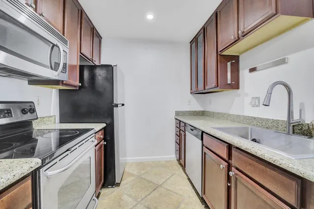 a kitchen with stainless steel appliances granite countertop a sink and a stove