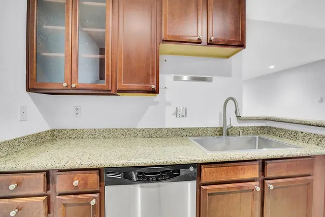 a kitchen with granite countertop a sink and cabinets