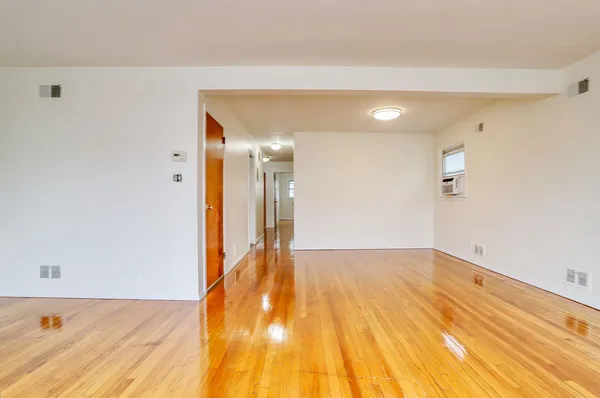 a view of a big room with wooden floor and a bathroom