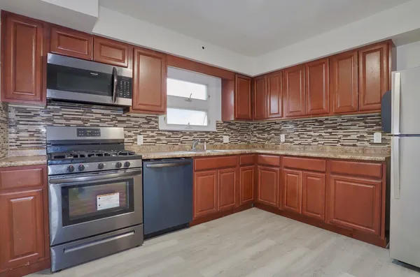 a kitchen with stainless steel appliances granite countertop a stove microwave and sink