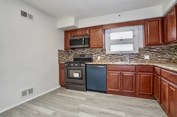 a kitchen with stainless steel appliances granite countertop a stove microwave and sink